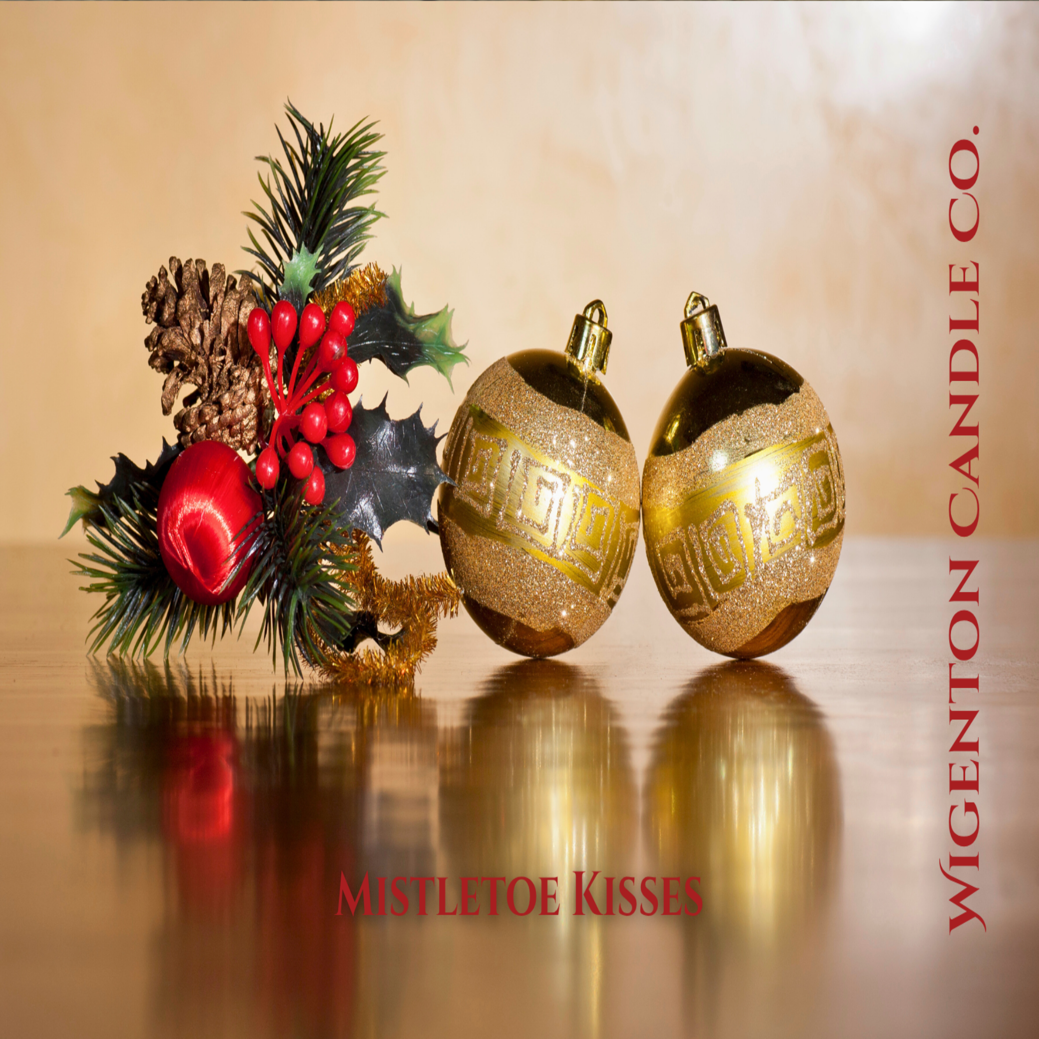 Decorative Christmas ornaments with mistletoe and pine cones on a reflective surface. This is a fragrance by Wigenton Candle Co.
