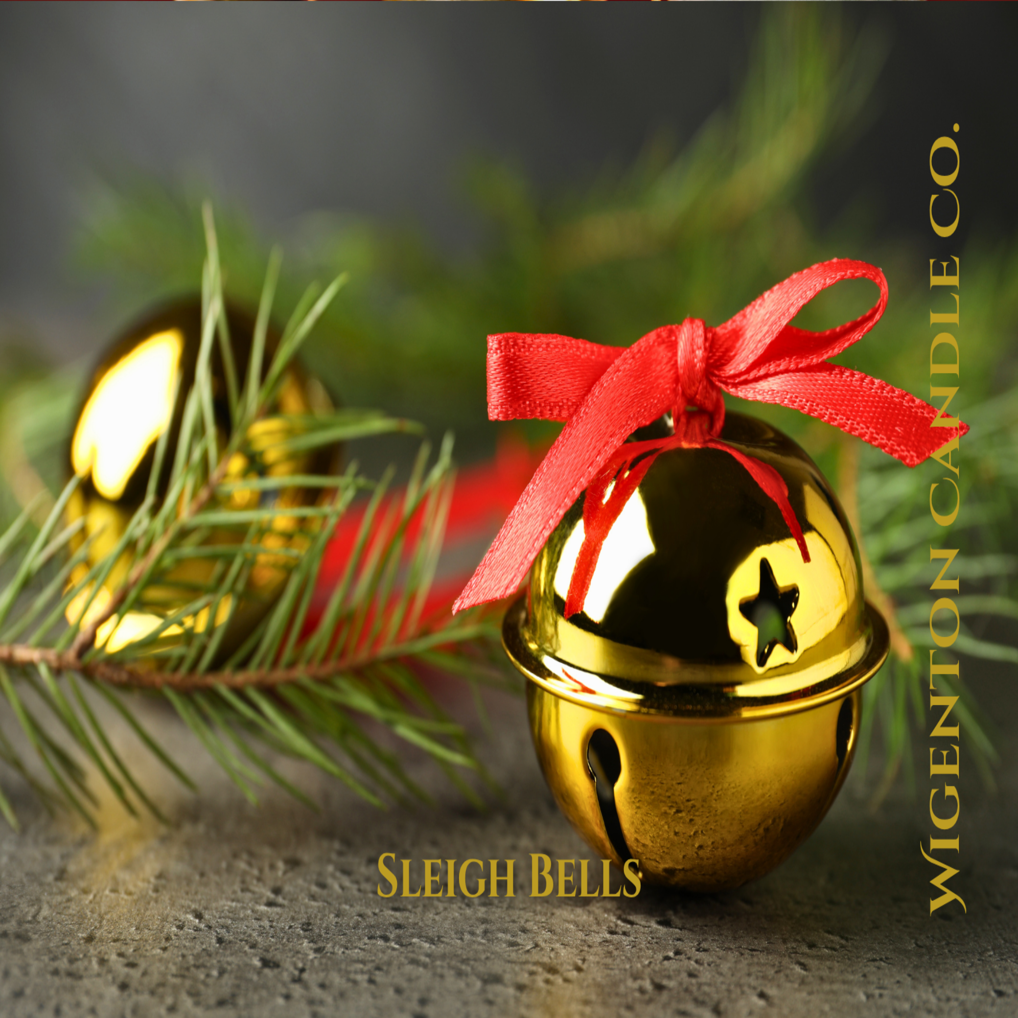Gold sleigh bells with a red ribbon on a stone surface with greenery. This is a fragrance by Wigenton Candle Co.