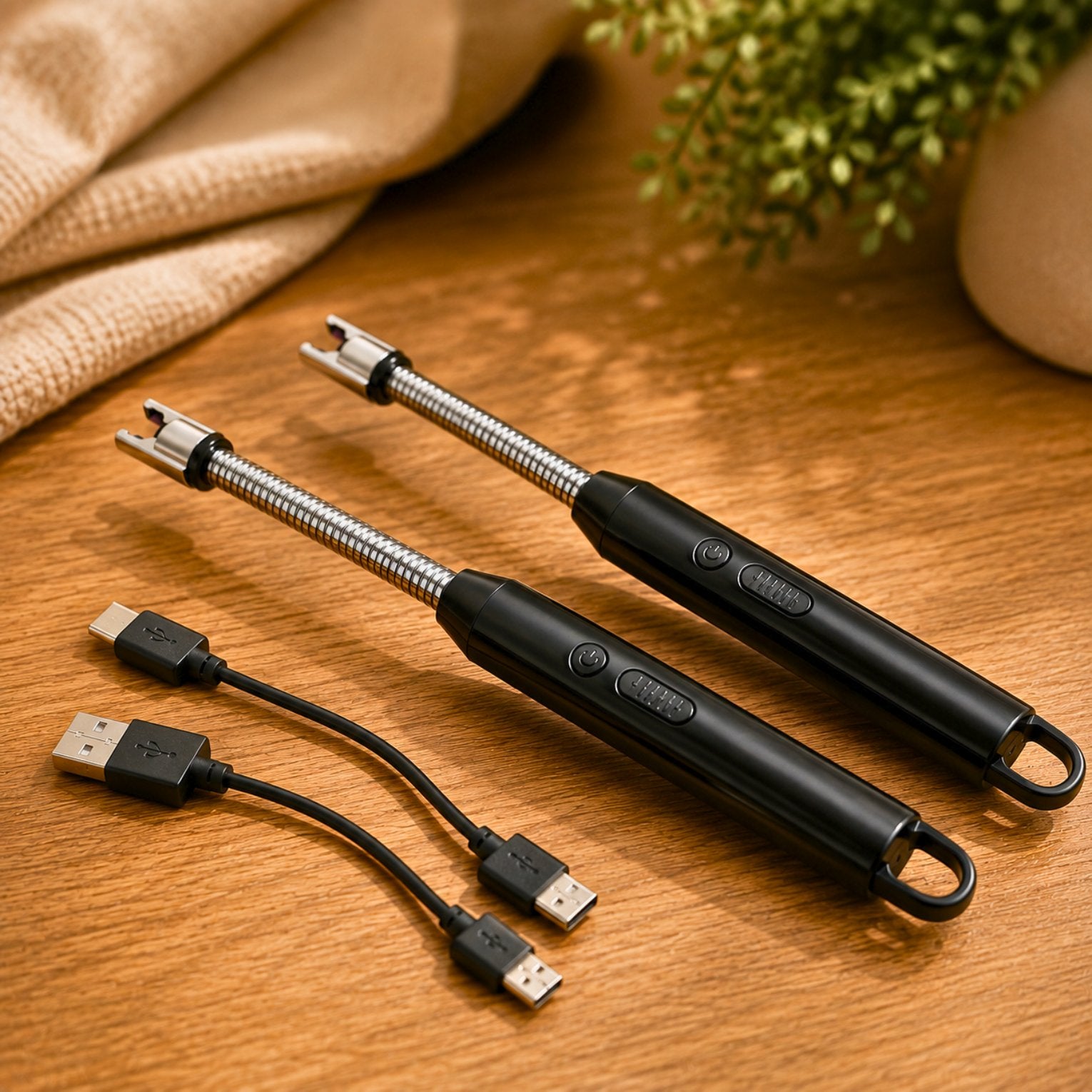 Two black rechargeable electric candle lighters with flexible silver necks and USB charging cables displayed on a warm wooden surface.