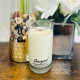 Candle labeled 'Energized' by Wigenton Candle Co. on a wooden surface with decorative elements.