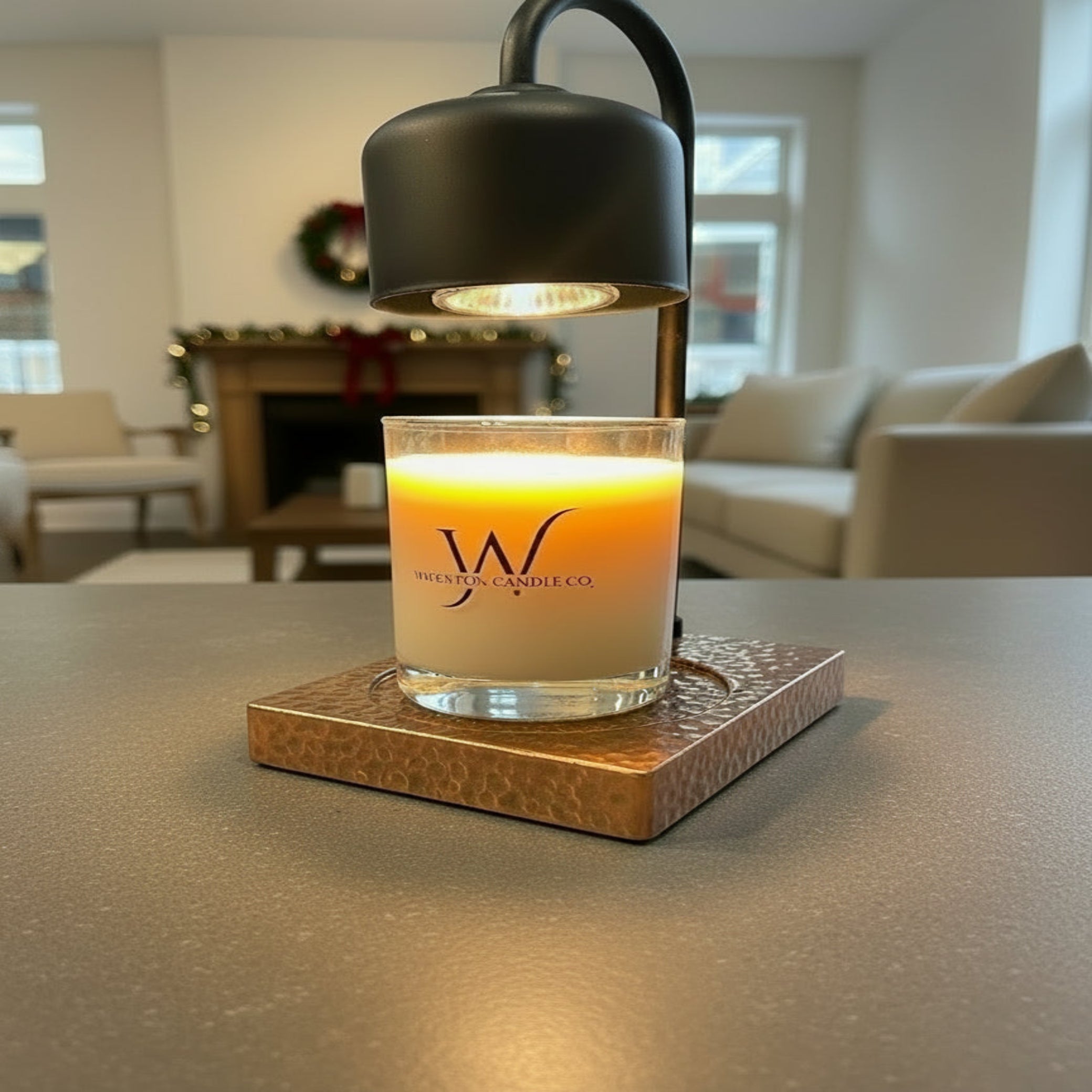 Black and wood arched candle warmer lamp warming a Wigenton candle in a modern living room.