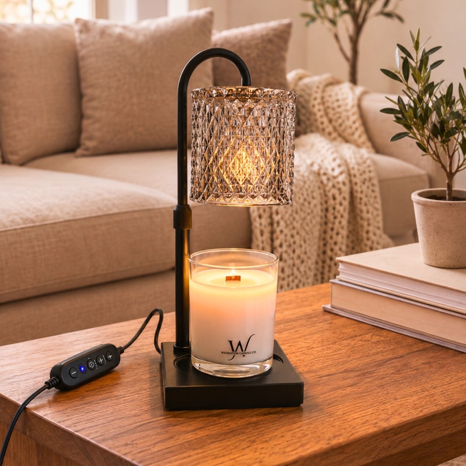 Faceted Glass Candle Warmer Lamp warming a Wigenton Candle Co. candle on a wood table in a cozy neutral living room.