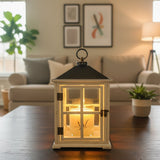 Cream-colored lantern with a glowing candle on a wooden coffee table in a cozy living room with warm light and neutral décor
