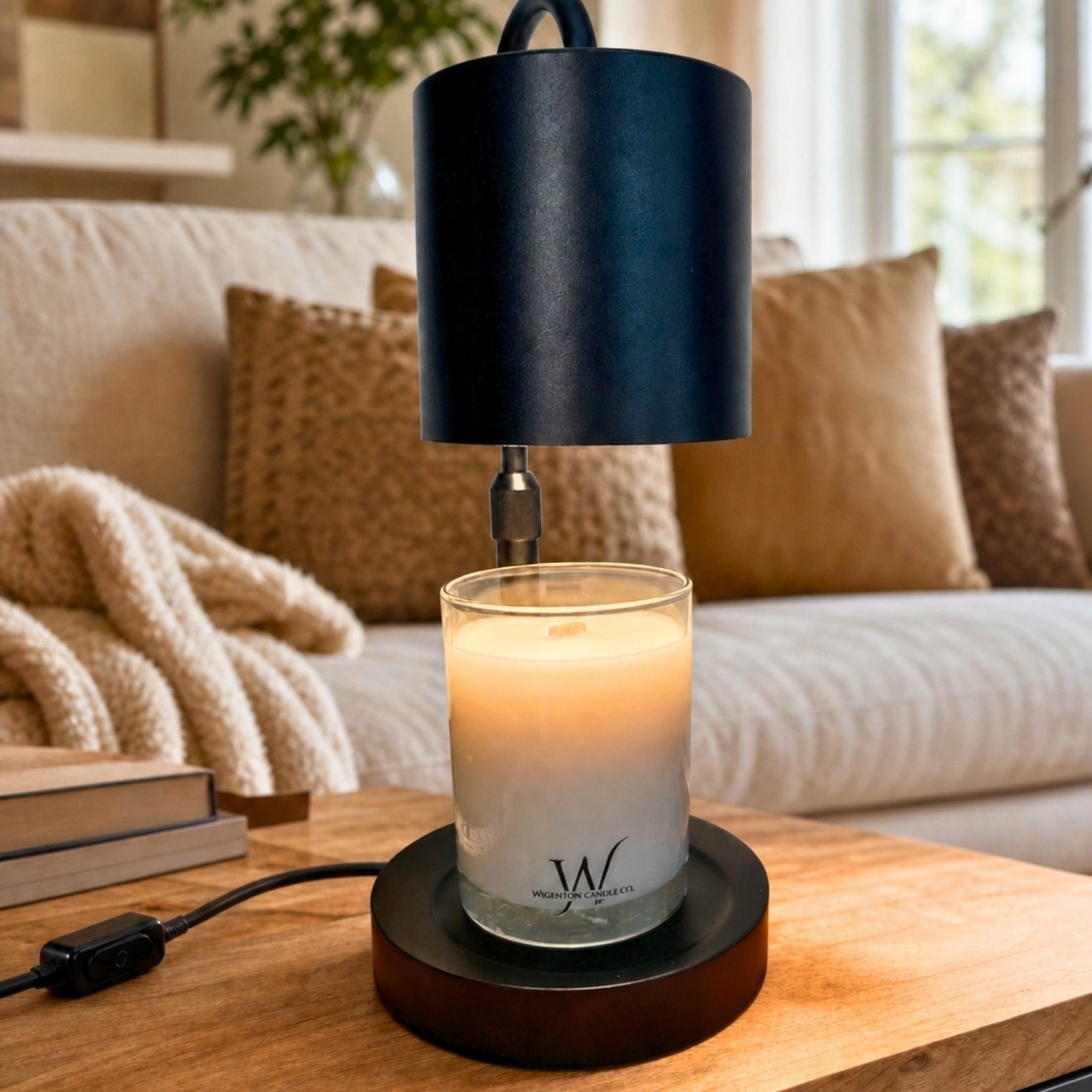 Matte Black Candle Warmer Lamp warming a Wigenton Candle Co. candle on a wood table in a cozy neutral living room.