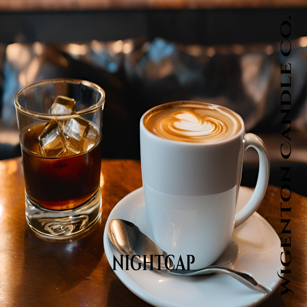White coffee cup with latte art on a saucer, glass of iced coffee, and spoon on a wooden table with 'NIGHTCAP' branding - Wigenton Candle Co. 