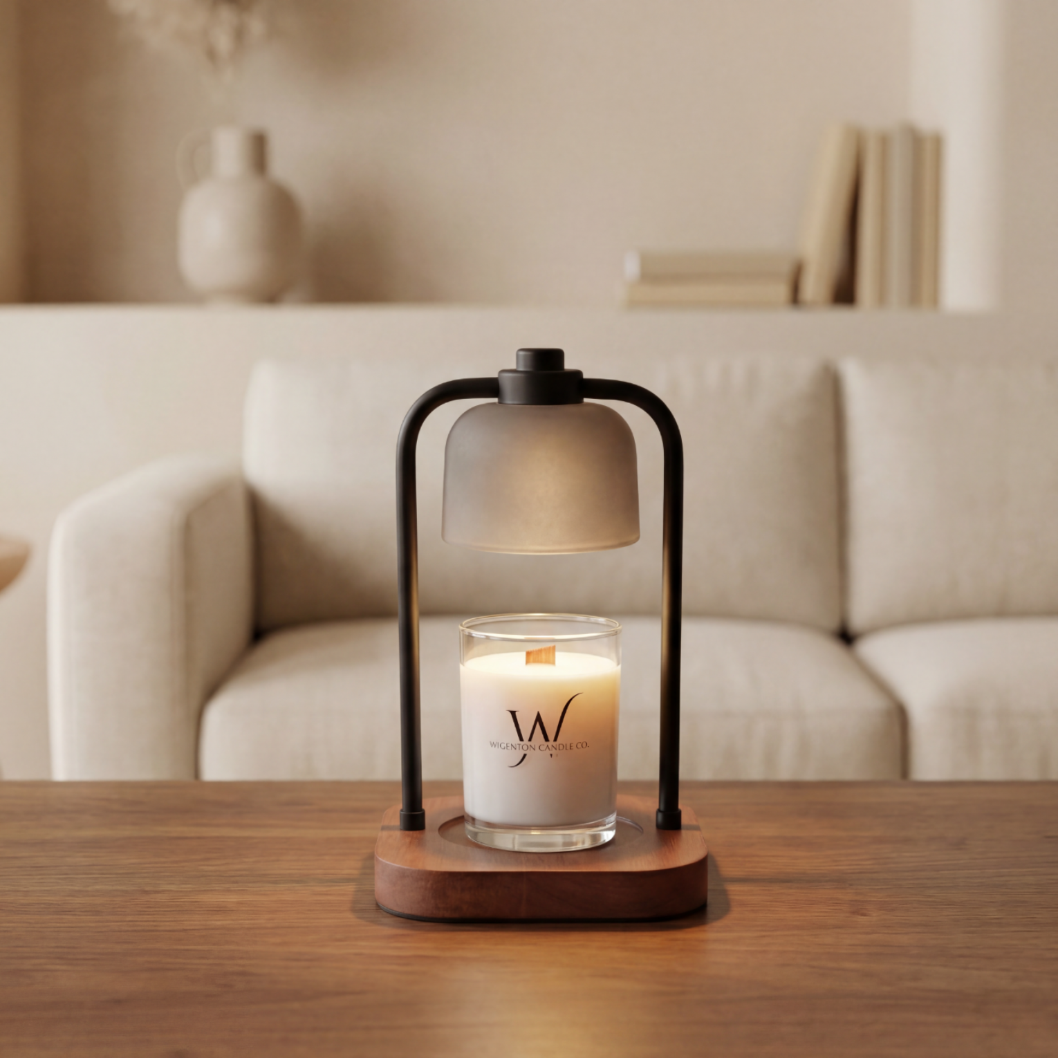 Candle in a glass holder with a wooden base on a table, set against a neutral living room background. Being melted by candle warmer lamp. 