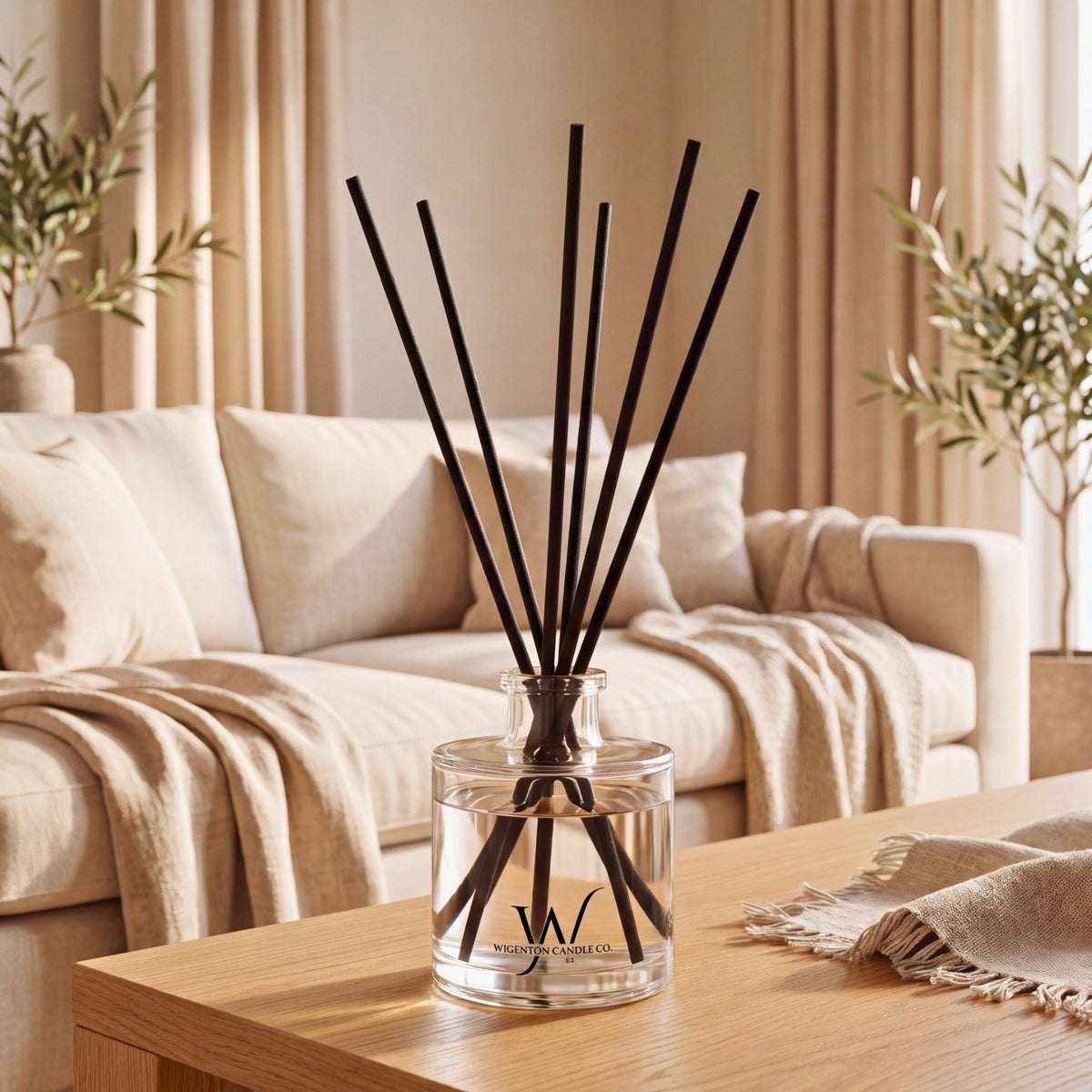 Wigenton Candle Co. 5 oz reed diffuser with black fiber reeds styled on a wood table in a warm, neutral living space.