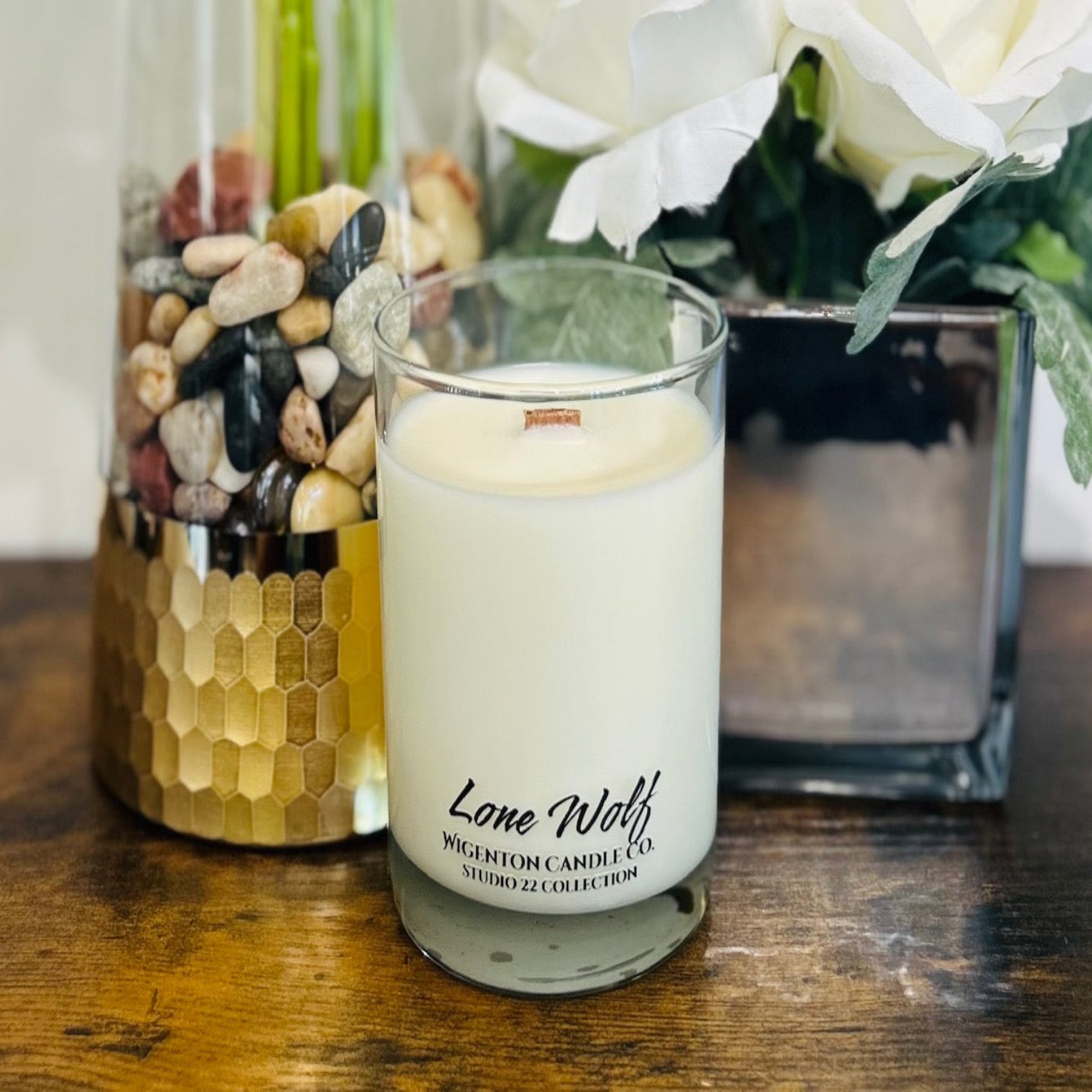 Candle with lone wolf fragrance in decorative vases on a wooden surface